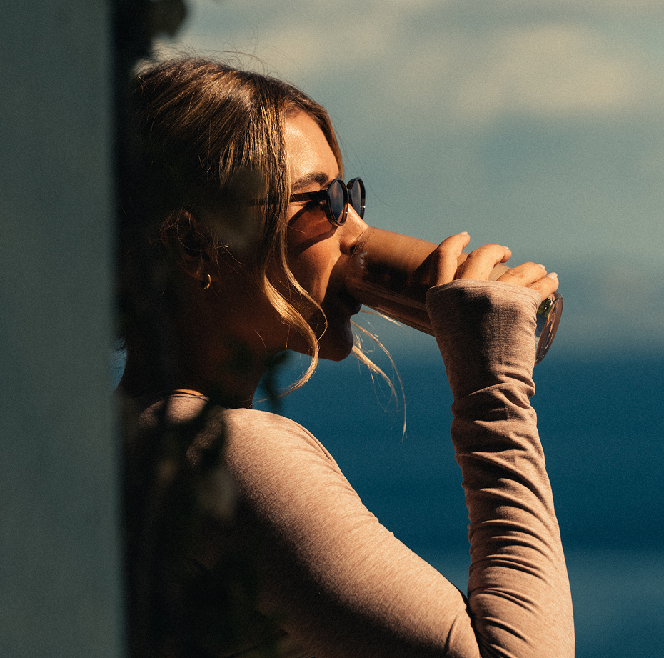 Woman drinking a protein beverage with a scenic background