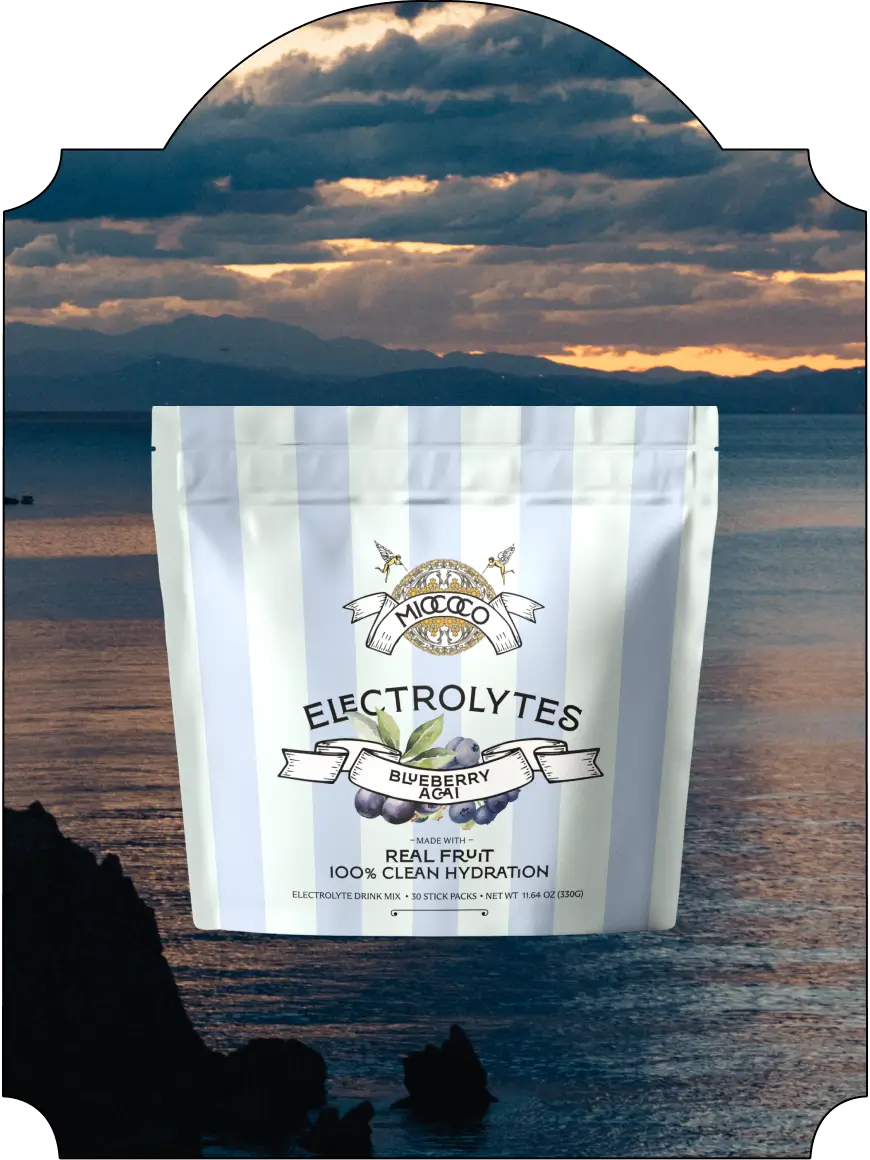 Pouch of MIOCOCO Blueberry Acai Electrolytes with a scenic background of mountains and sunset.